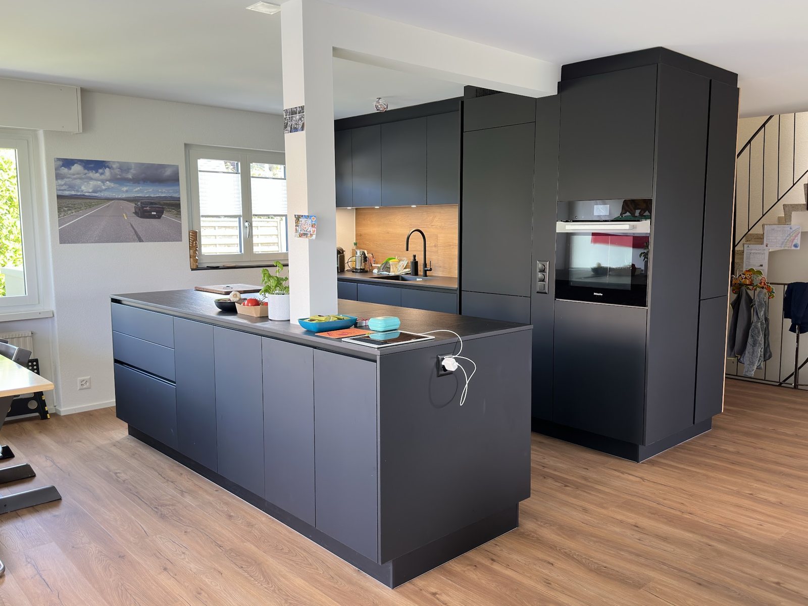 Küche mit dunkler Insel und Hochschrank im Eigenheim