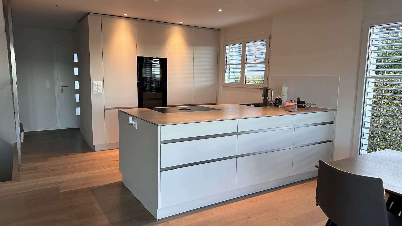 Küche mit weisser Insel und Backofen im Hochschrank