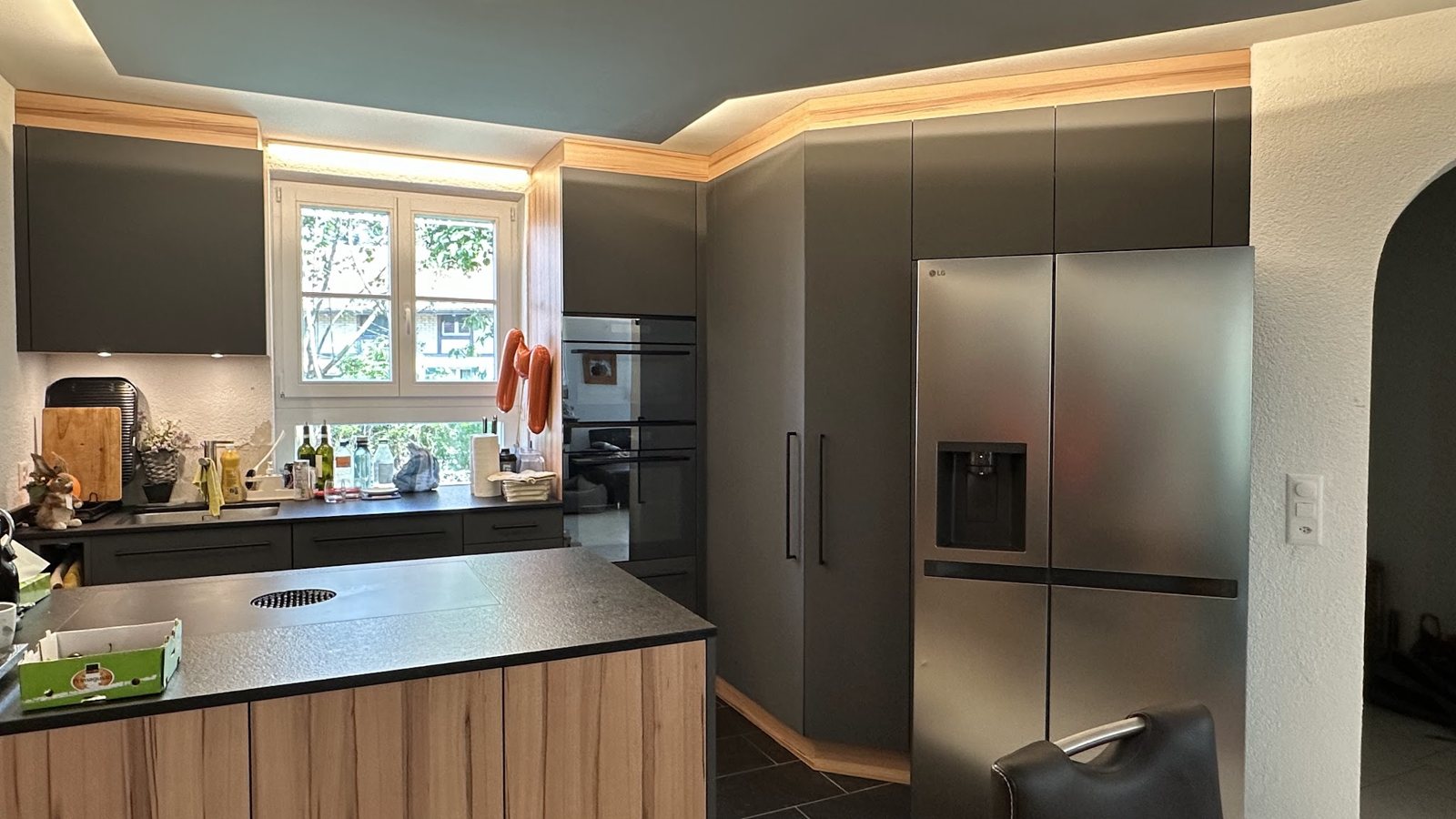 Küche mit Holzinsel, Kühlschrank und Fenstern
